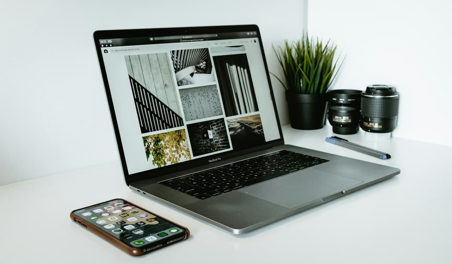 Laptop su una scrivania bianca che mostra un sito web di galleria fotografica.